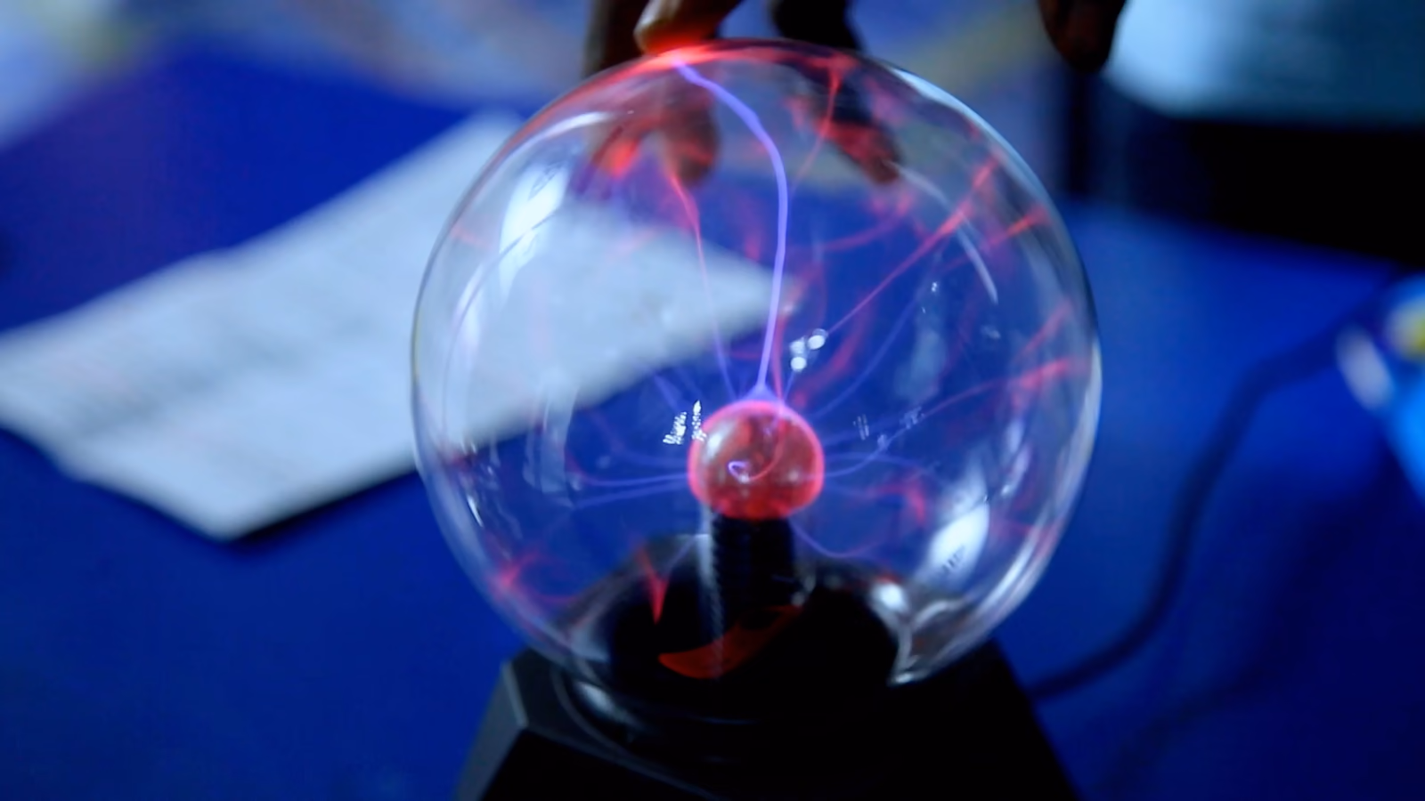 A participant exploring a plasma globe during a STEM learning activity