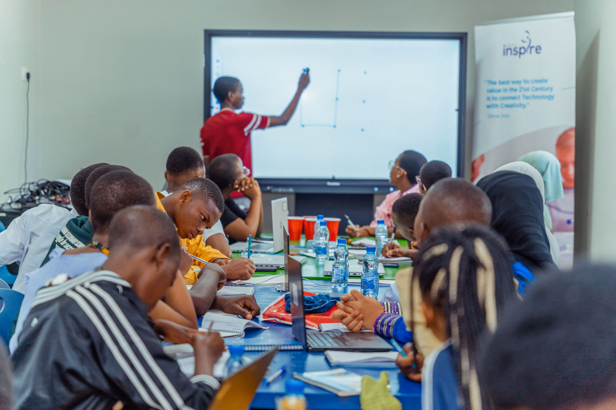 Young people working with laptops and notebooks during a Projekt Inspire bootcamp
